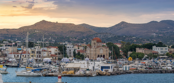Skyline of the island of Aegina: a small harbour, a church and mountains in the background. 